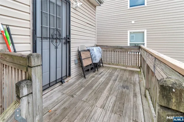 a view of a balcony with wooden floor and chair