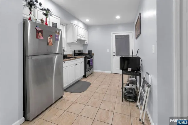 a kitchen with stainless steel appliances granite countertop a refrigerator and a stove top oven