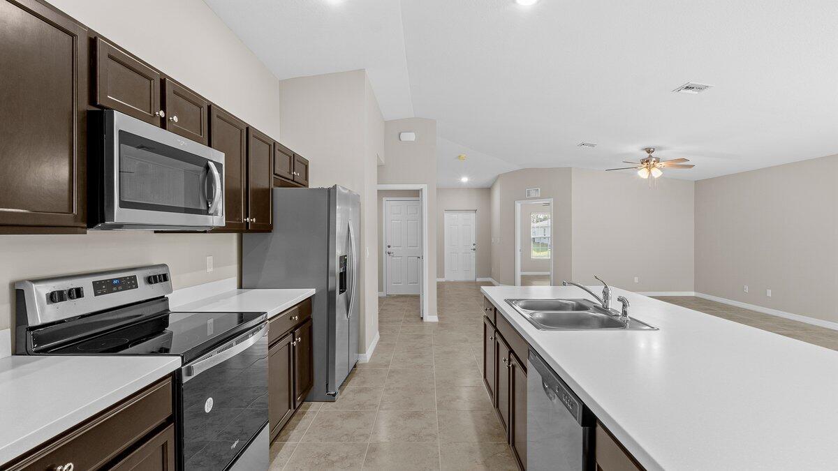 1213 Ragen Road Southeast Palm Bay, FL 32909 - Photo 11 of 26 a kitchen with a sink stove and refrigerator