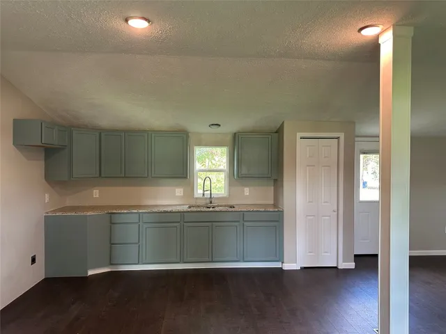 a kitchen with granite countertop a sink and a stove top oven
