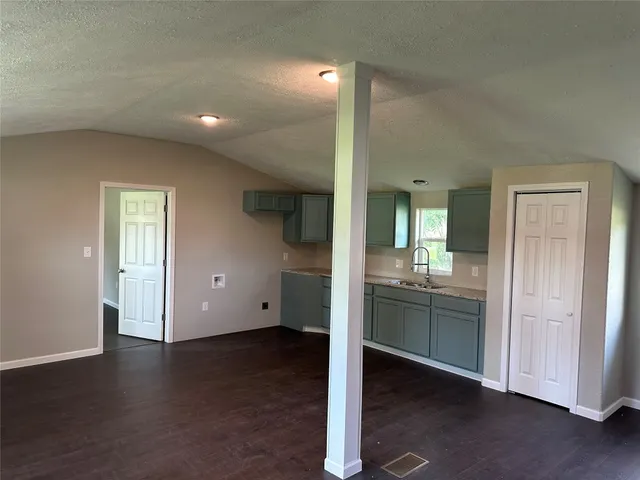a view of kitchen with kitchen island wooden floor center island and stainless steel appliances