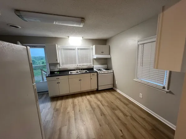 a kitchen with a sink window and cabinets