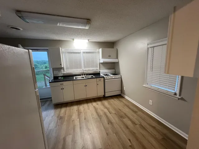 a kitchen with a sink window and cabinets