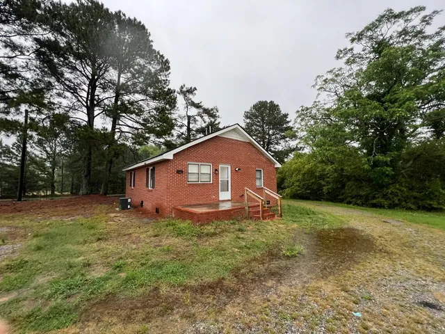 a view of a big house with a tree and a yard