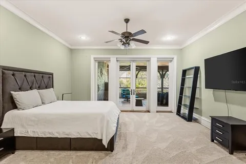 a bedroom with a bed dresser and a chandelier