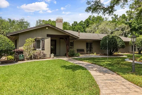 a view of a house with backyard and sitting area