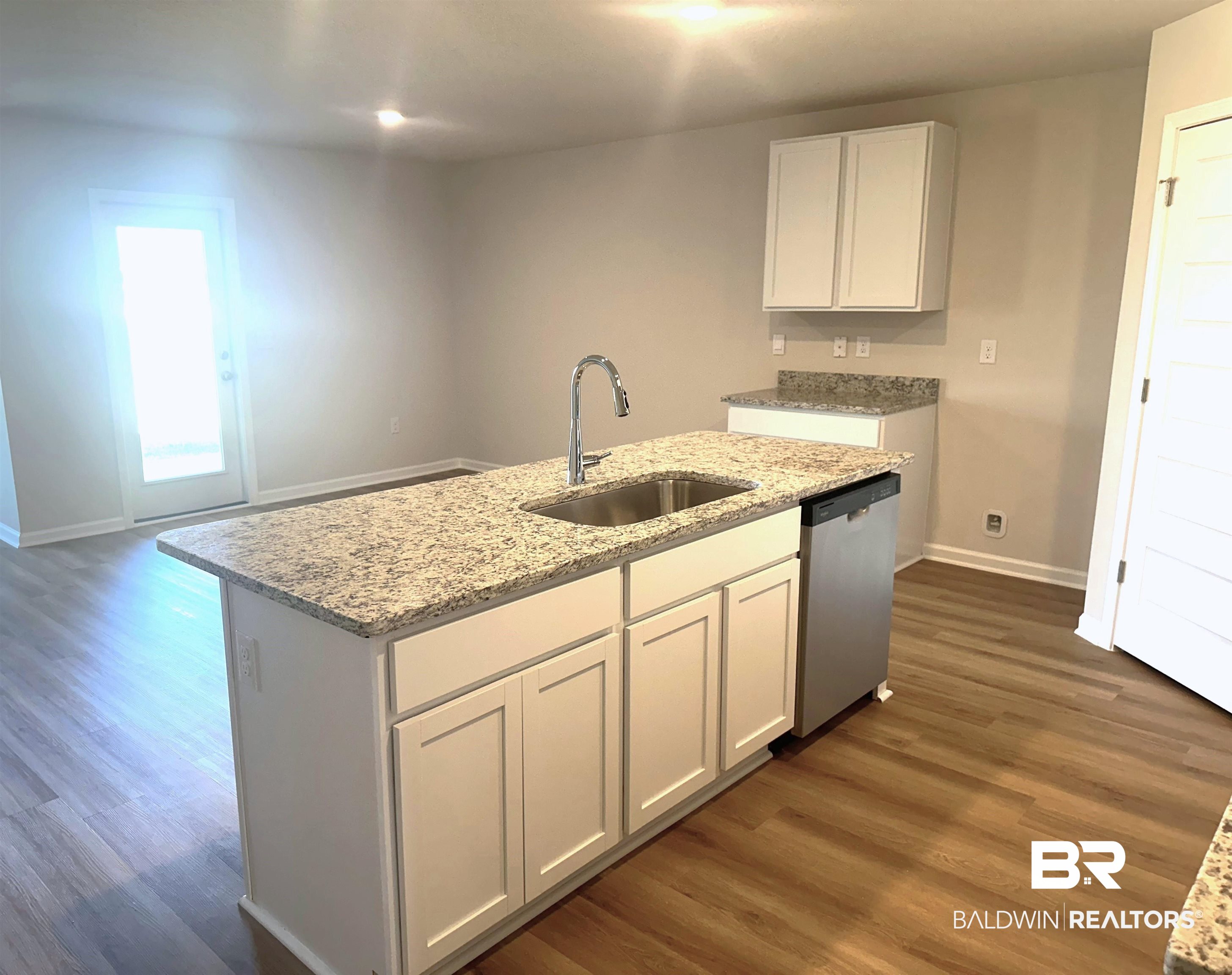 1234 Hayward Loop Foley, AL 36535 - Photo 4 of 31 Kitchen featuring a center island with sink, white cabinetry, sink, dark wood-type flooring, and stainless steel dishwasher