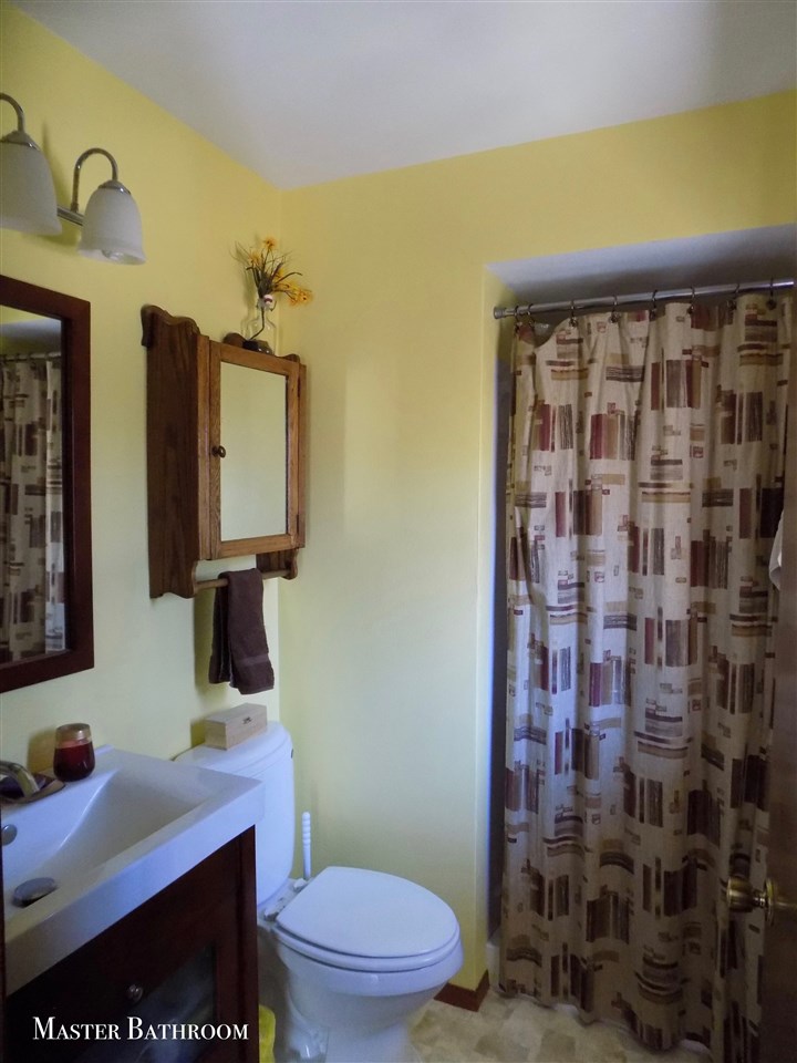 4401 Centerville Road Rockford, IL 61102 - Photo 11 of 23 a bathroom with a sink a toilet and mirror