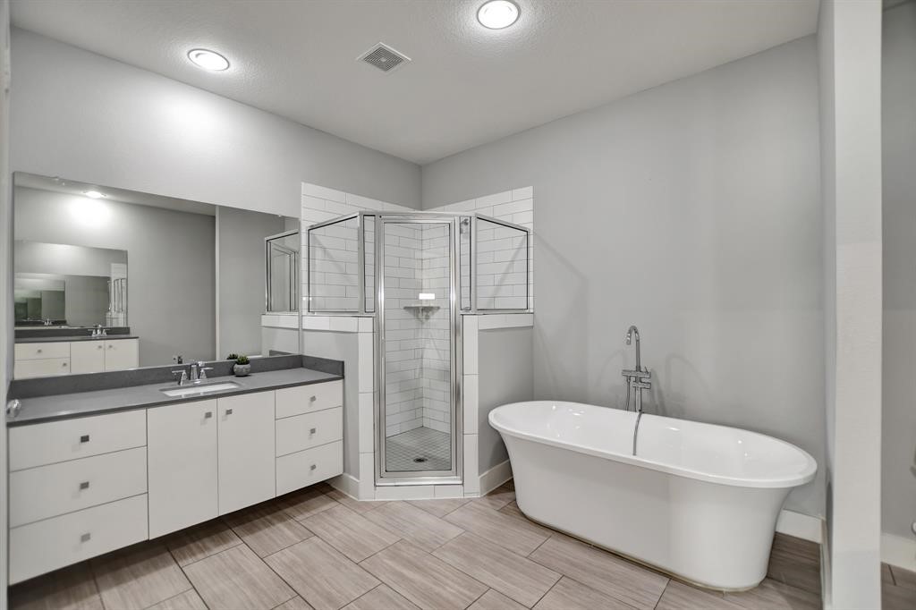20 Evanston Street Houston, TX 77015 - Photo 24 of 31 a bathroom with a double vanity sink a mirror and a bathtub