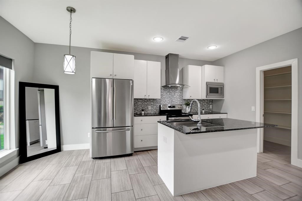 20 Evanston Street Houston, TX 77015 - Photo 4 of 31 a kitchen with stainless steel appliances granite countertop a refrigerator a stove a sink and a microwave