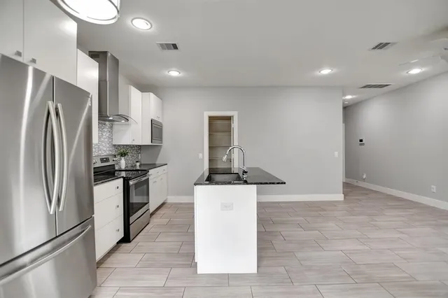 a kitchen with stainless steel appliances granite countertop a refrigerator and a stove