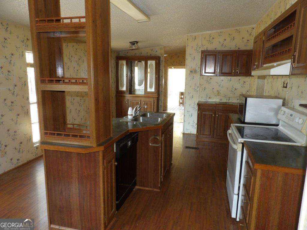 111 Sunnyside Drive Box Springs, GA 31801 - Photo 9 of 18 a kitchen with a refrigerator and wooden cabinets