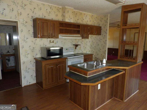 a kitchen with stainless steel appliances granite countertop a stove a sink and a microwave