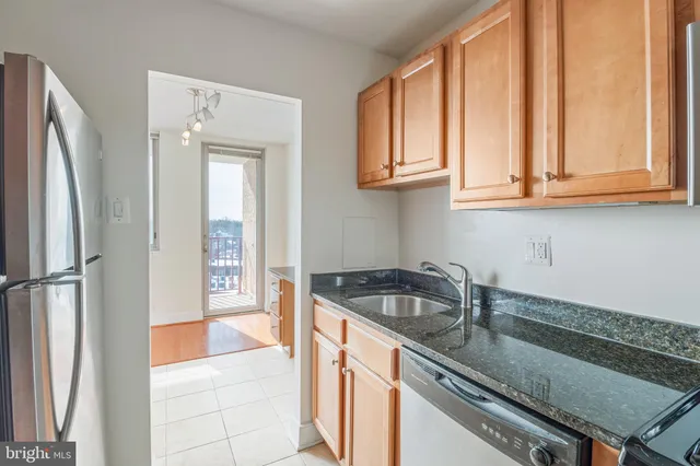 a kitchen with granite countertop a sink and a refrigerator