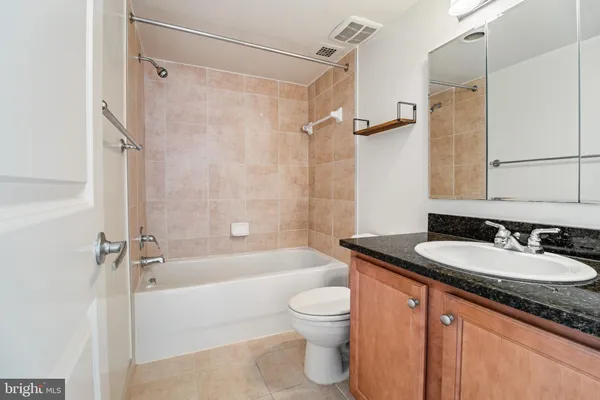 a bathroom with a granite countertop sink toilet and shower