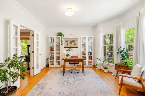a living room with furniture a bookshelf and a window
