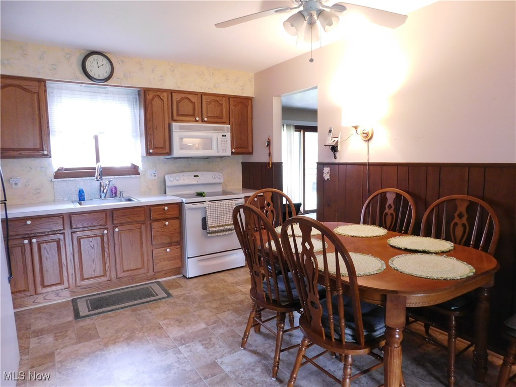 9255 Root Road North Ridgeville, OH 44039 - Photo 5 of 46 Kitchen featuring visible vents, a sink, ceiling fan, white appliances, and brown cabinetry