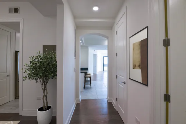 a view of a hallway with wooden floor and closet