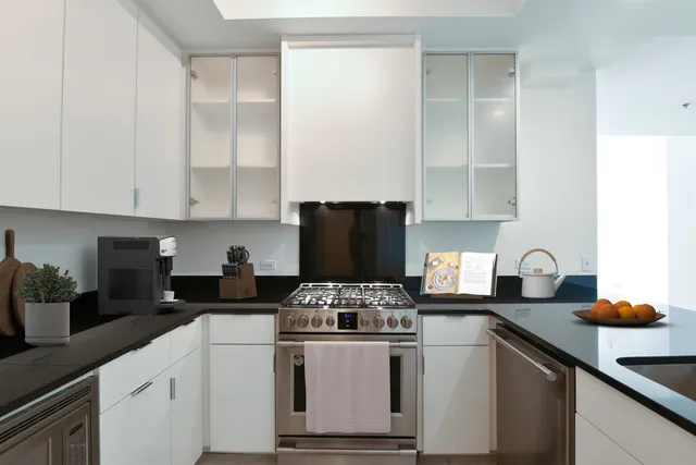 a kitchen with granite countertop white cabinets and white appliances