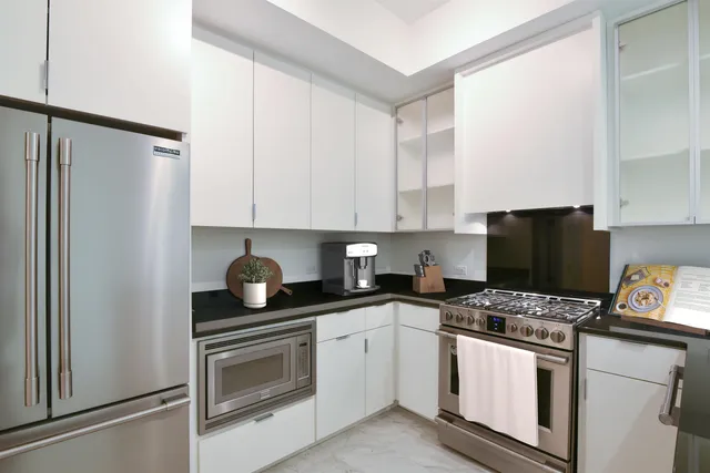 a kitchen with appliances a sink and cabinets