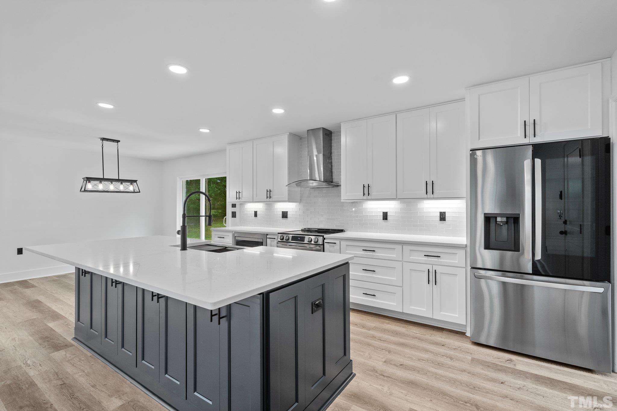 1102 Jerome Road Durham, NC 27713 - Photo 13 of 41 a kitchen with a sink a refrigerator and white cabinets