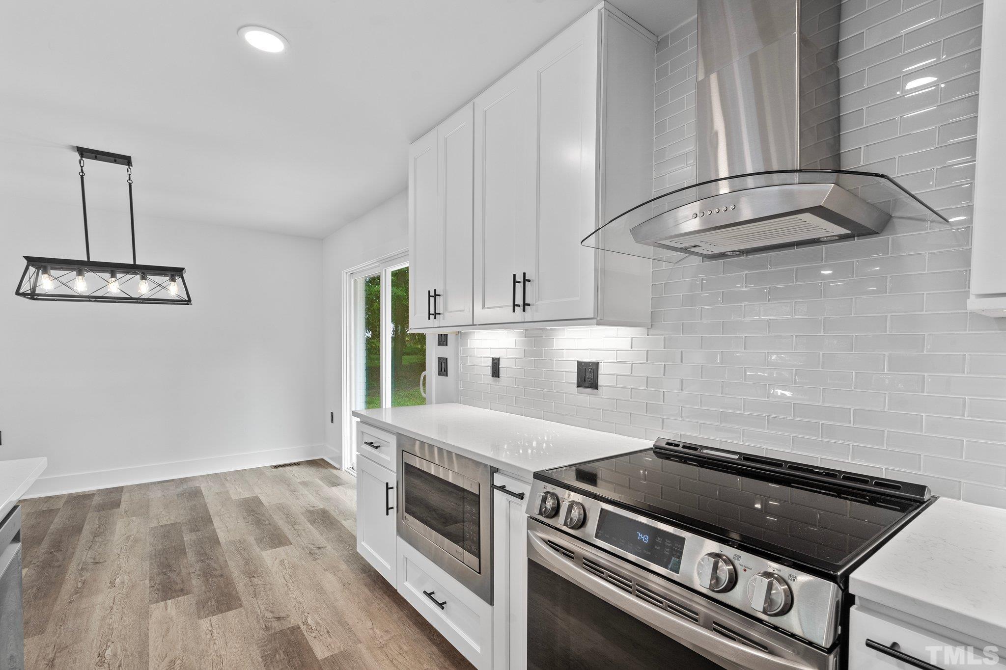 1102 Jerome Road Durham, NC 27713 - Photo 14 of 41 a kitchen with granite countertop a stove and a microwave