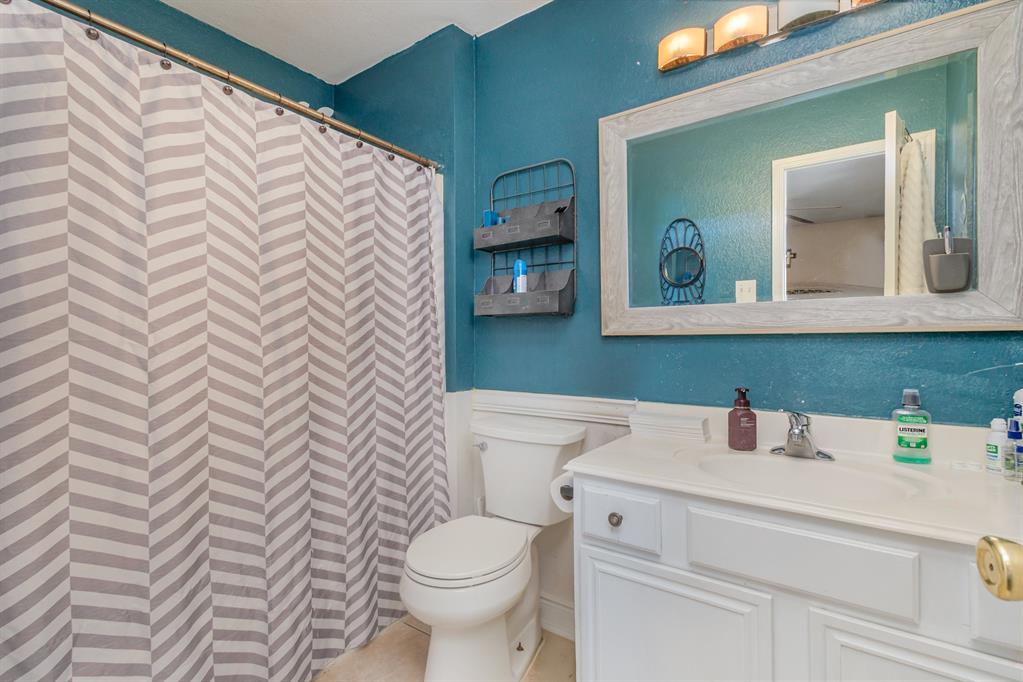 13444 Vida Lane Dallas, TX 75253 - Photo 12 of 17 a bathroom with a sink a toilet and mirror