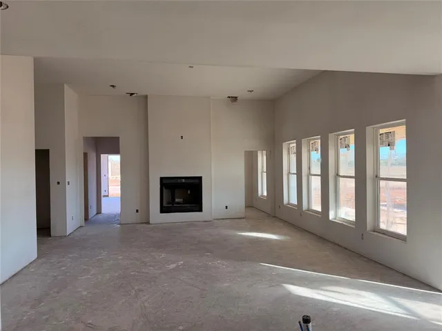 a view of an empty room with a fireplace and a window