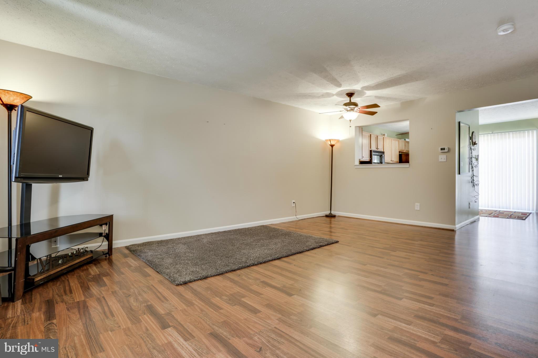 639 Nollmeyer Road Baltimore, MD 21220 - Photo 3 of 28 a view of a livingroom with a flat screen tv wooden floor and a ceiling fan