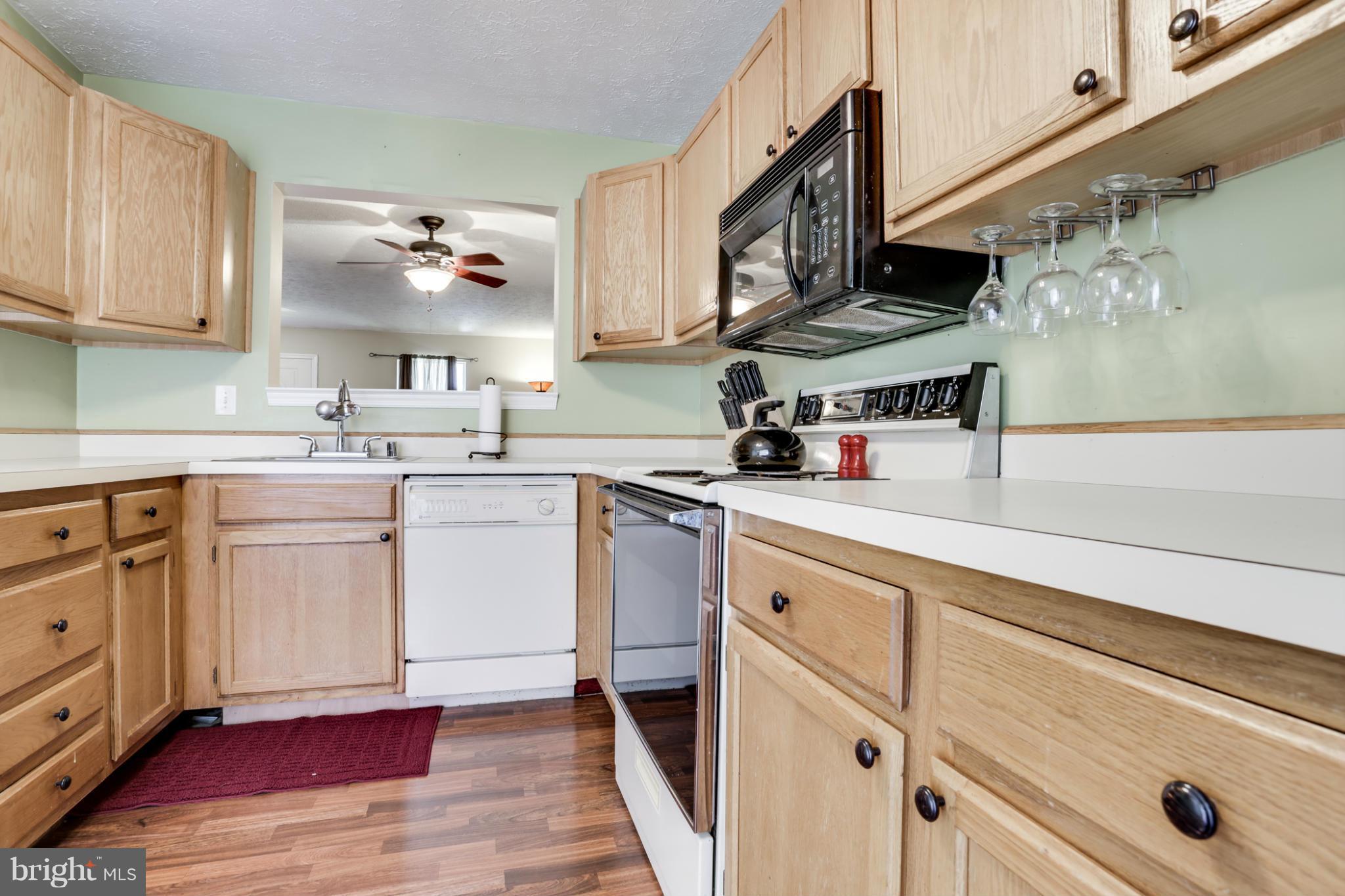 639 Nollmeyer Road Baltimore, MD 21220 - Photo 8 of 28 a kitchen with cabinets wooden floor and stainless steel appliances