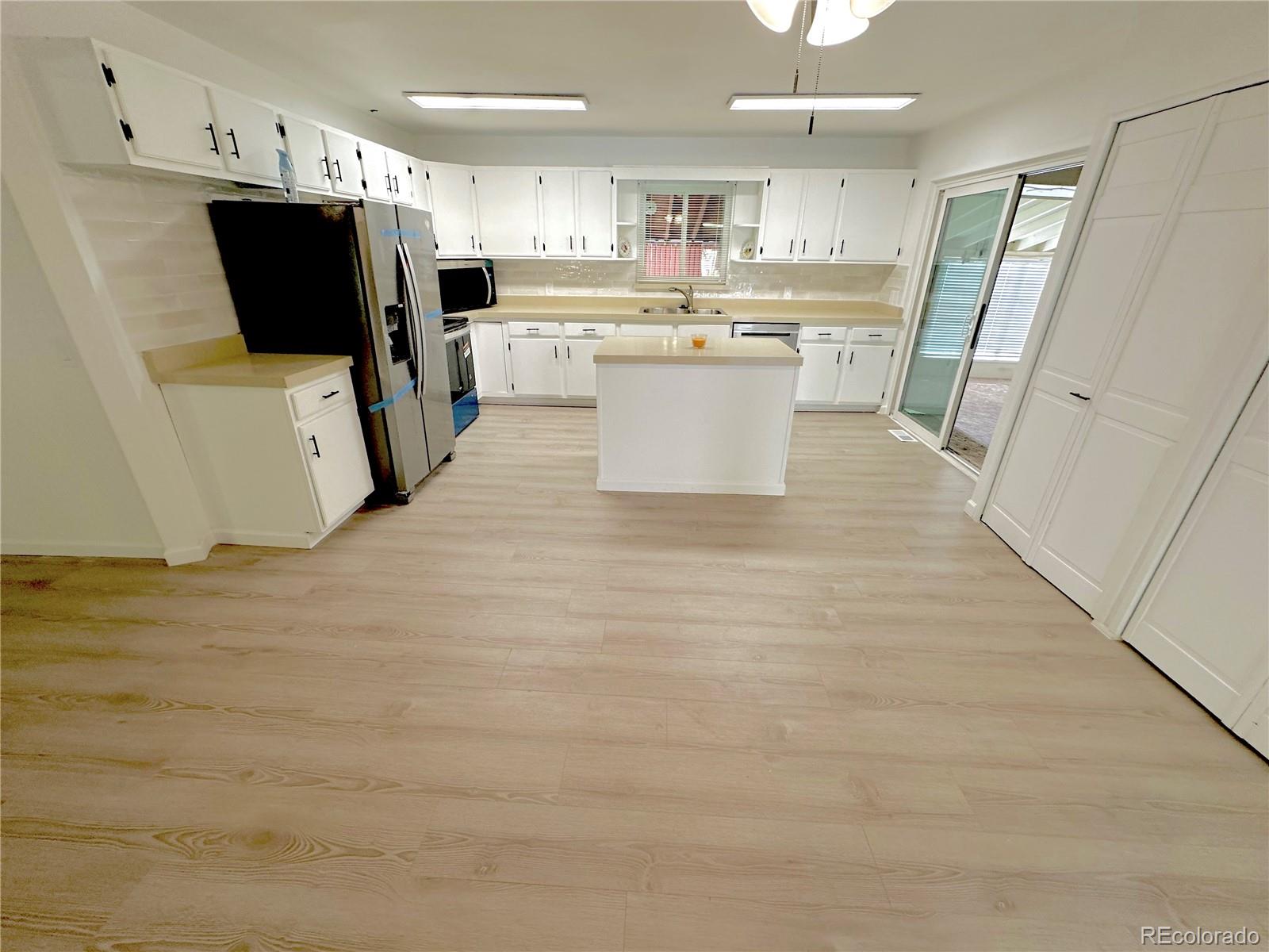 423 Empire Street Aurora, CO 80010 - Photo 4 of 44 a kitchen with stainless steel appliances a refrigerator sink and microwave