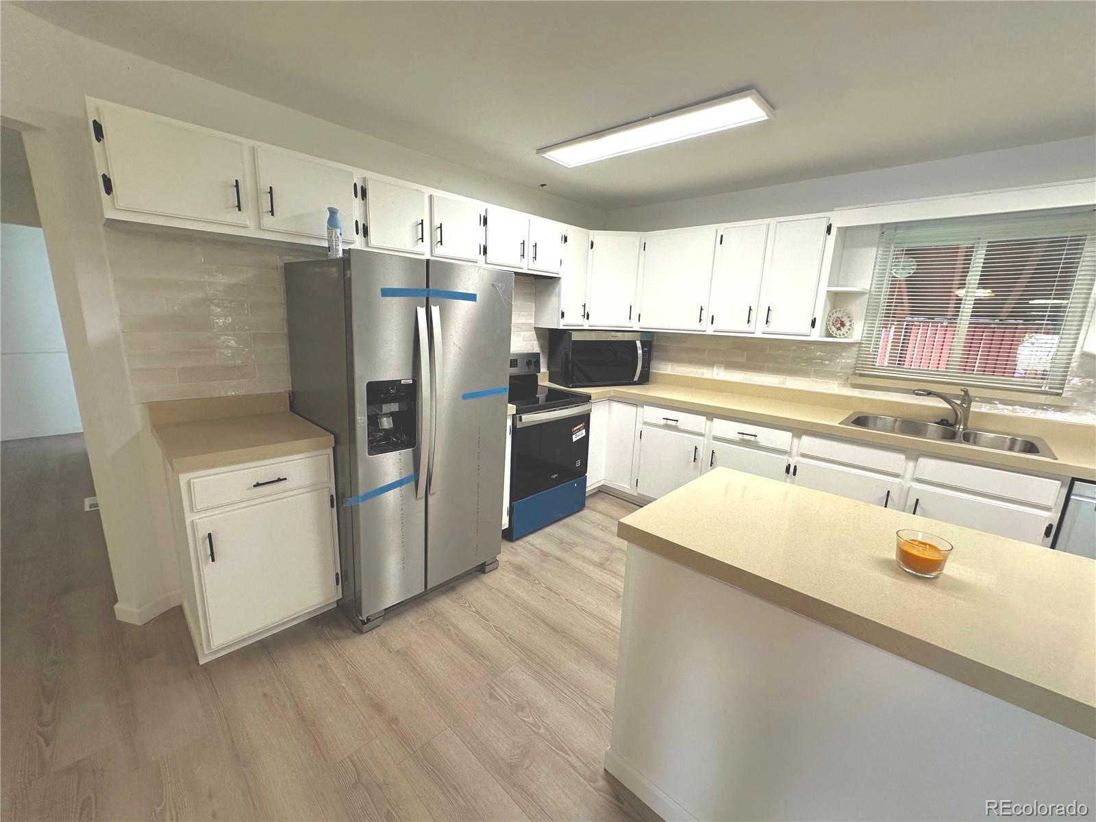 423 Empire Street Aurora, CO 80010 - Photo 7 of 44 a kitchen with stainless steel appliances a refrigerator sink and cabinets