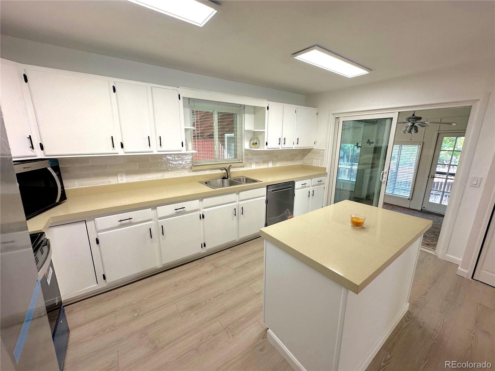 423 Empire Street Aurora, CO 80010 - Photo 8 of 44 a kitchen with white cabinets sink and white appliances