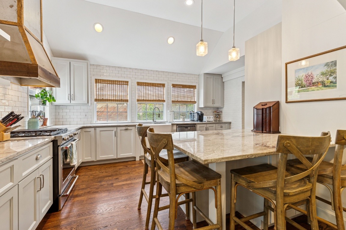 210 Cherokee Road Nashville, TN 37205 - Photo 16 of 56 a kitchen with stainless steel appliances granite countertop a stove top oven a sink a dining table and chairs with wooden floor