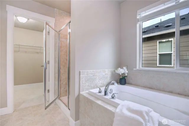 a bathroom with a tub shower and mirror