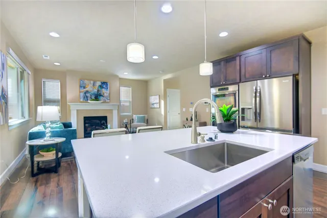 a kitchen with a refrigerator a sink and a fireplace