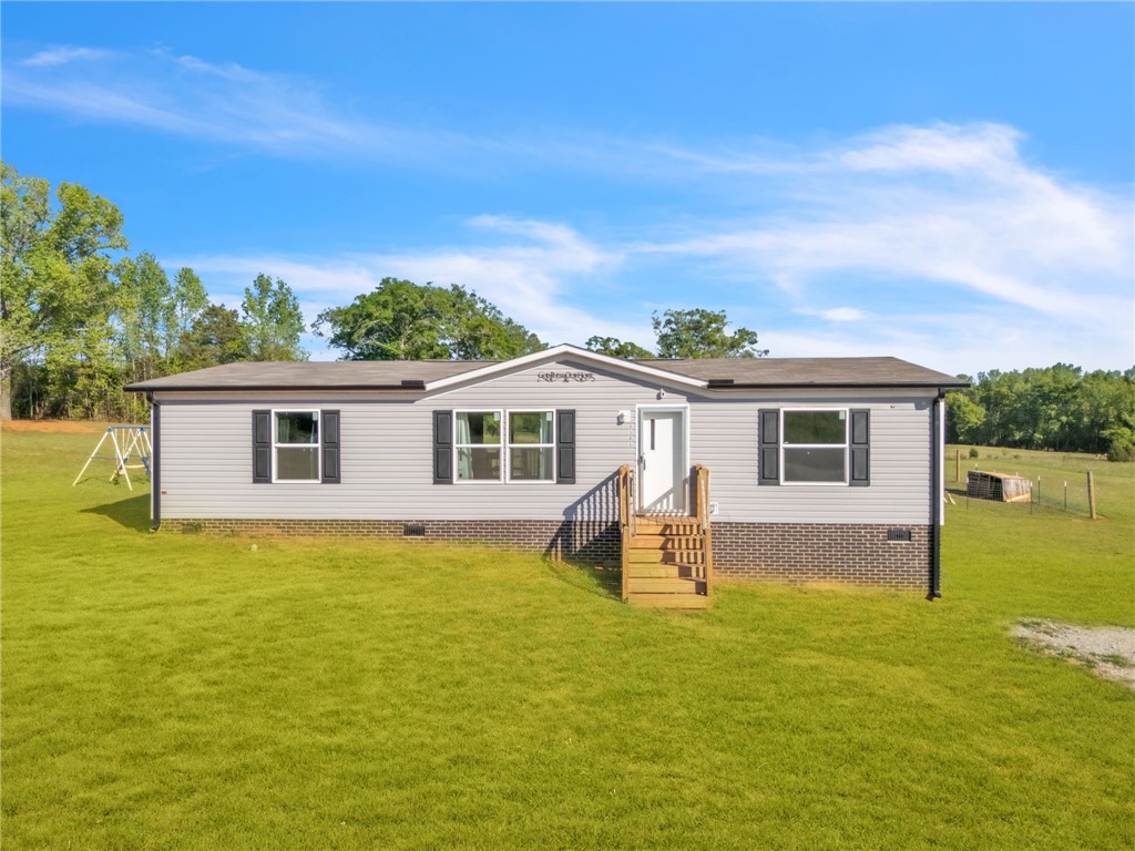 5303 Highway 413 Iva, SC 29655 - Photo 2 of 27 This charming residence offers comfortable living amidst a serene, expansive green landscape.