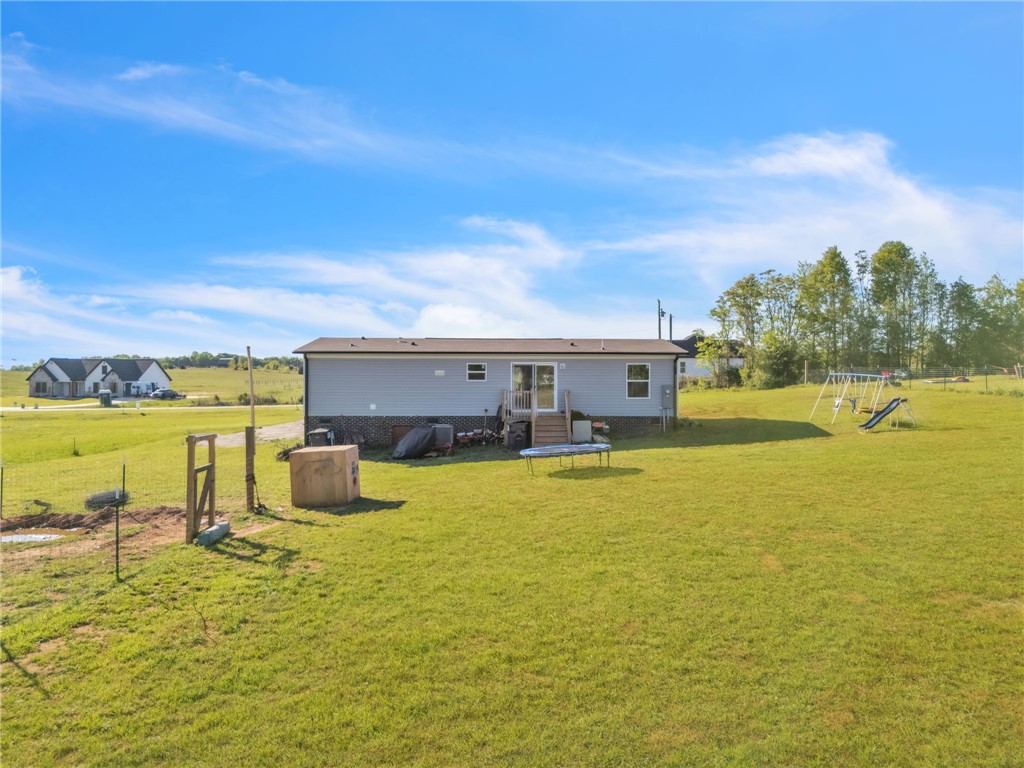 5303 Highway 413 Iva, SC 29655 - Photo 24 of 27 A spacious backyard with a swing set and ample room for outdoor activities.