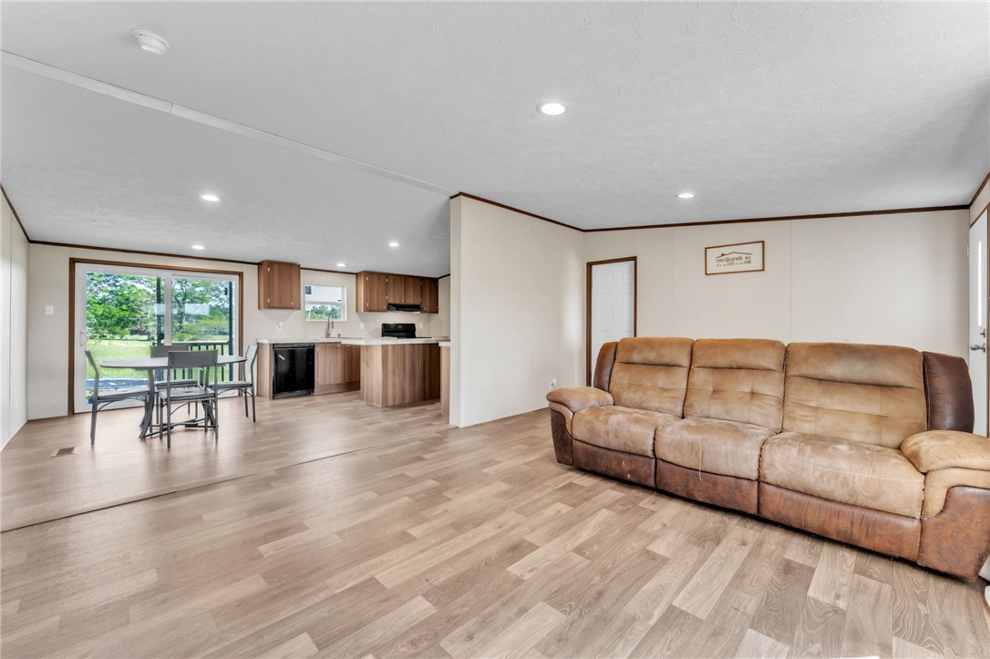 5303 Highway 413 Iva, SC 29655 - Photo 7 of 27 This bright living area features sleek flooring, leading to a modern kitchen and dining space.