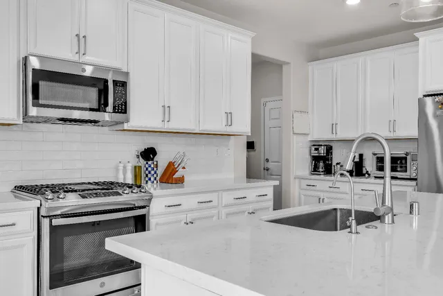 a kitchen with stainless steel appliances a stove microwave and white cabinets