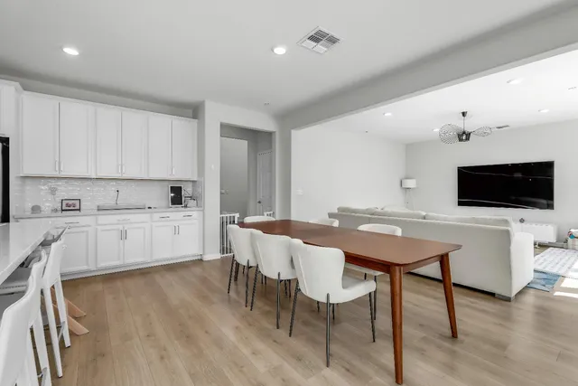 a kitchen with stainless steel appliances a microwave a stove a table and chairs