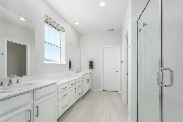 a bathroom with a double vanity sink and mirror