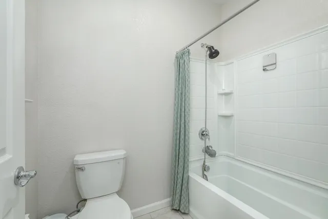 a bathroom with a toilet and shower