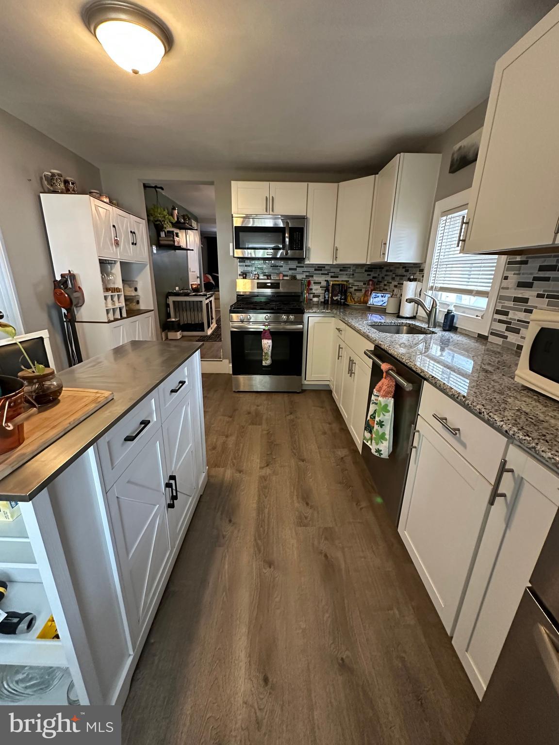 203 Mill Street Mount Holly, NJ 08060 - Photo 6 of 19 a kitchen with white cabinets sink and stove