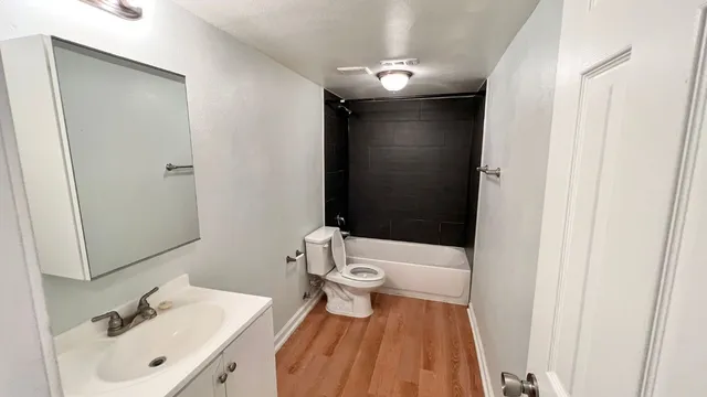 a bathroom with a sink a toilet and shower