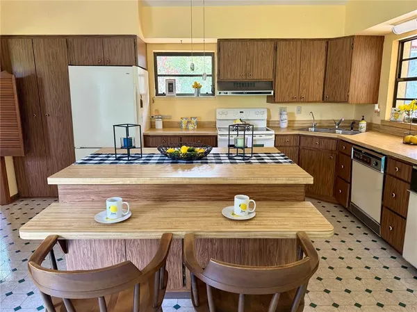 a kitchen with a stove sink and cabinets