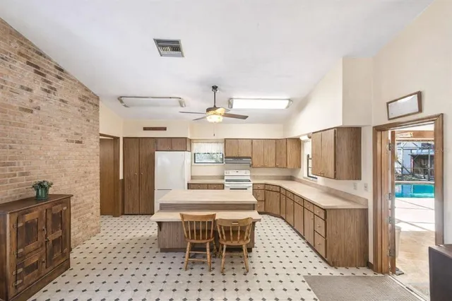a kitchen with a table chairs refrigerator and microwave