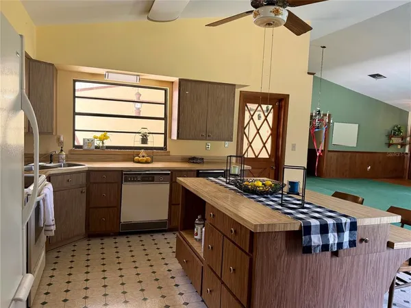 a kitchen with a sink and chairs