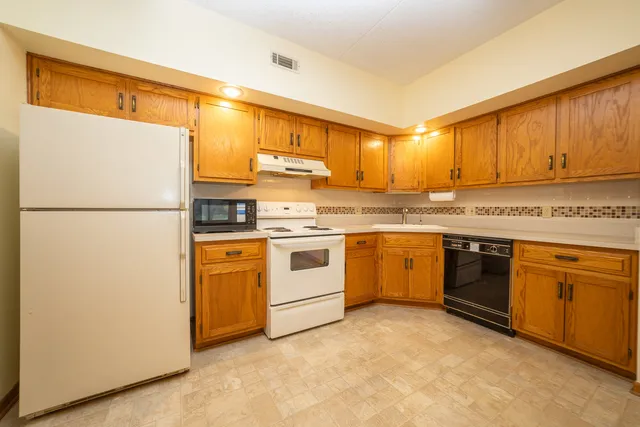 a kitchen with stainless steel appliances granite countertop a sink and cabinets with wooden floor