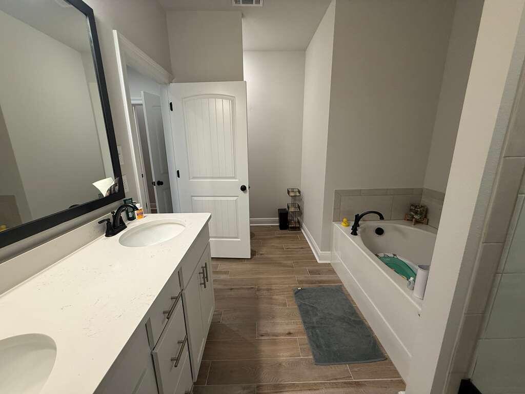 115 Apollo Avenue Freeport, FL 32439 - Photo 14 of 26 a bathroom with a double vanity sink and mirror with bathtub
